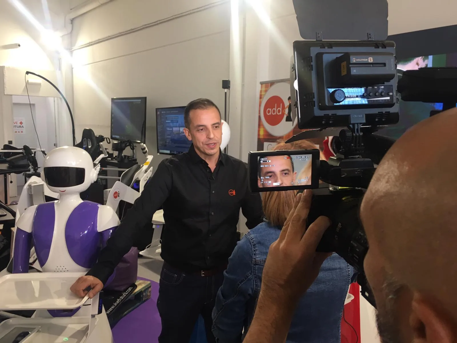 Rob Futura durante una entrevista para CNN junto a robots.